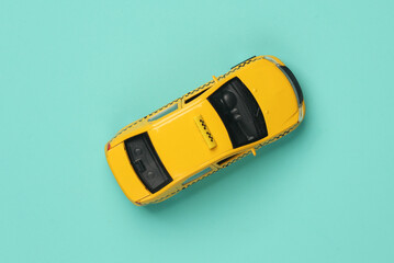 Toy taxi car model top view on blue background