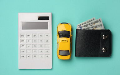 Toy taxi car model with calculator and purse on blue background. Business concept. Top view