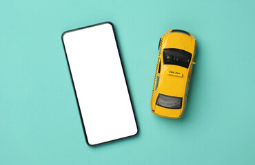 Toy taxi car model with smartphone on yellow background. Top view
