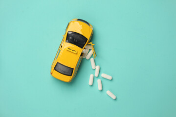 Taxi car with pills on a blue background. Top view