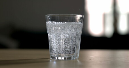 Pouring sprinkling water into glass cup . Serving hydrating drink