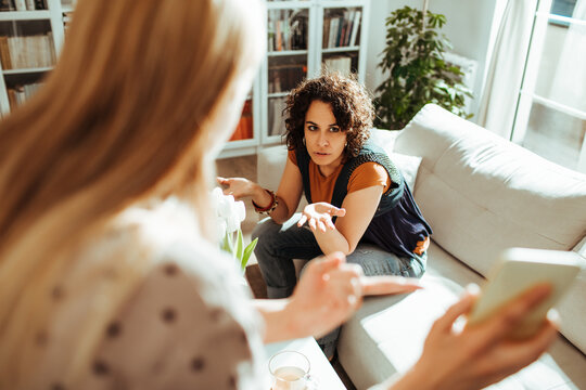 Lesbian couple arguing about text messages in the living room