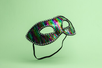 Carnival masquerade mask flying in antigravity on green background with shadow. Levitation object...