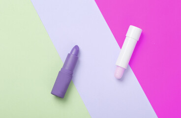 Hygienic and pink make-up lipstick on a colored background. Creative beauty layout. Top view