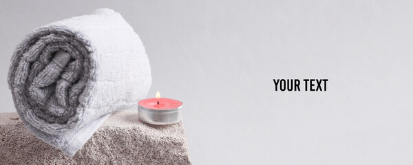 Spa salon, relaxation concept. Aromatherapy. Towel with scented candle on gray background. Copy...