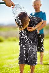 Children, boys and hose pipe with water fun, splash and playing outdoor in backyard or garden for...