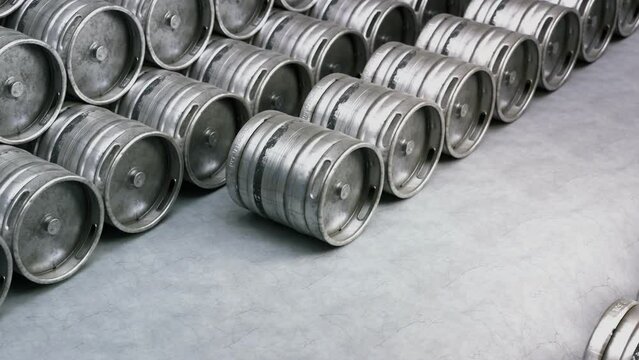 Multiple metal beer kegs stacked on the ground in endless, seamless loop. 4K HD