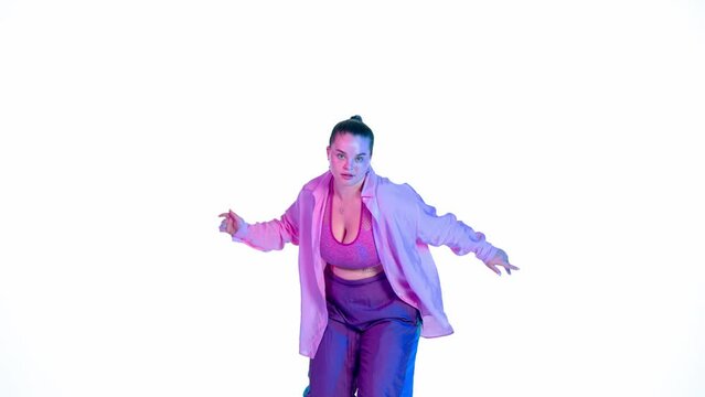 Attractive woman dancing jazz-funk on white isolated background in a studio. Blue and pink spotlight, energetic dance choreography. Medium full.