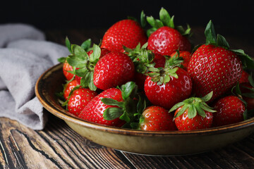 A bowl with ripe bright strawberry in rustic style	