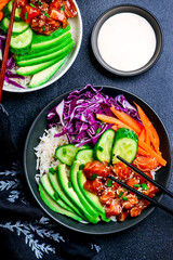 Salmon poke bowl with vegetables and avocado.top veiw