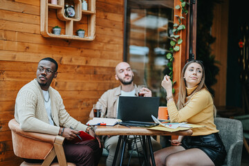 Young executives plan business expansion in an urban coffee bar. They discuss market analysis, financial planning, and creative marketing campaigns with angel investors and startup funding.
