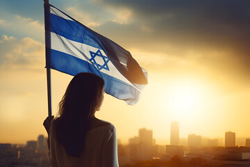A young woman holds the flag of Israel in her hands - obrazy, fototapety, plakaty
