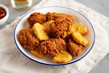 Homemade Chicken Nuggets and Chicken Wings with Ketchup and Beer, side view.