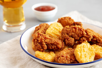 Homemade Chicken Nuggets and Chicken Wings with Ketchup and Beer, low angle view. Close-up.