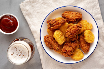 Homemade Chicken Nuggets and Chicken Wings with Ketchup and Beer, top view.