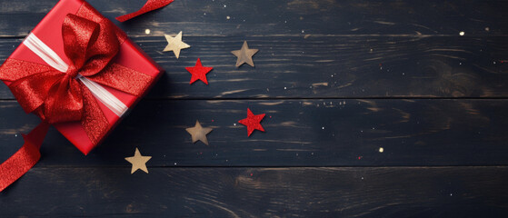 Christmas decoration with red ribbon on dark rustic wooden background.
