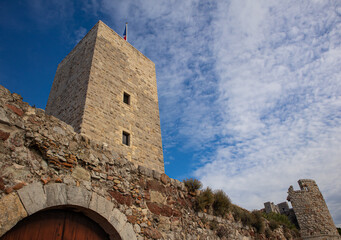 A tower on the arch with a cloudy blue sky on the background