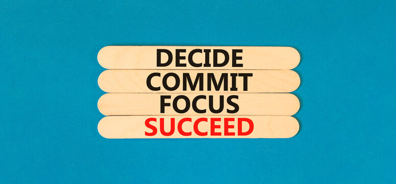 Decide commit focus succeed symbol. Concept word Decide Commit Focus Succeed on beautiful wooden stick. Beautiful blue table blue background. Business decide commit focus succeed concept. Copy space.
