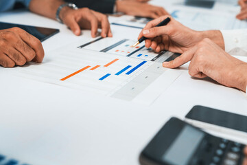 Analyst team utilizing BI Fintech to analyze financial data at table in meeting room. Businesspeople analyzing BI dashboard power on paper for business insight and strategic marketing planning.Prudent