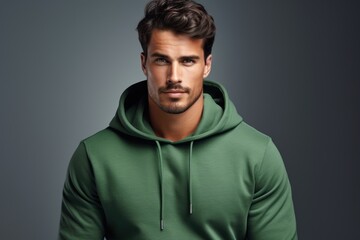 Fototapeta premium Photo of a handsome man in a warm hooded sweatshirt on a plain background