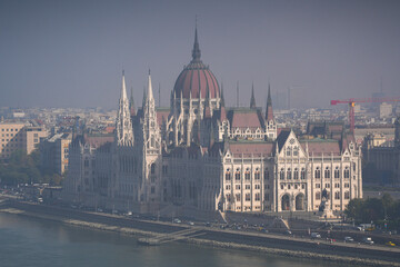 Obraz premium Hungarian Parliament building. View from above over the Budapest Parliament landmark construction, next to Danube river, during a foggy summer morning. Travel to Hungary.