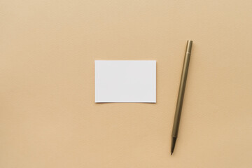blank white card and pen on the table, top view