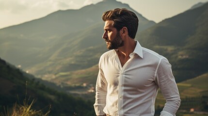 Photo of a handsome man in a stylish white dress shirt against the backdrop of beautiful mountains. Style and fashion concept.