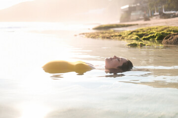 A pregnant woman with a big belly lies in the water, her belly sticks out of the water. Meditation...