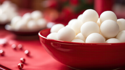 Greeting card for Chinese Dongzhi festival (Winetr Solstice) with tasty tangyuan on red background - obrazy, fototapety, plakaty