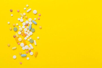 Different medical pills and capsules on color background, top view