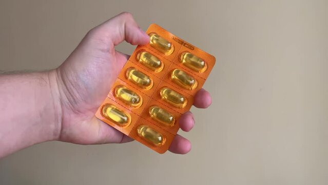 mano con blister de capsulas amarillas