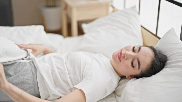 Young beautiful hispanic woman lying on bed sleeping at bedroom