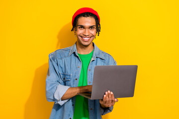 Photo of cheerful nice man dressed trendy clothes use modern technology macbook isolated on vivid yellow color background