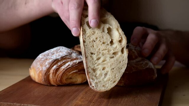 Attractive young Caucasian chef showing a slice of sourdough bread.