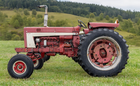 Faded red tractor in field
