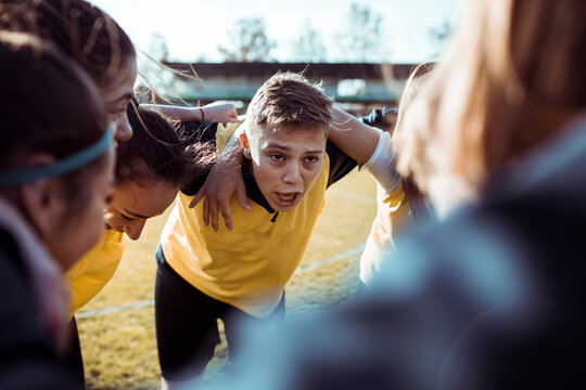 Female youth soccer team having a huddle on the field