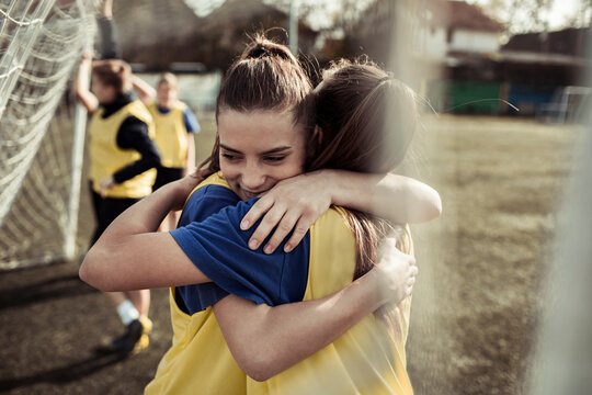 Fototapeta Two young female soccer players hugging during practice