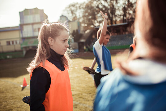 A focused young soccer player listens intently during team practice