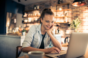 Smiling woman working on her laptop at home