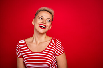 Photo of positive cute girl wear stylish clothes looking news novelty poster empty space isolated on red color background