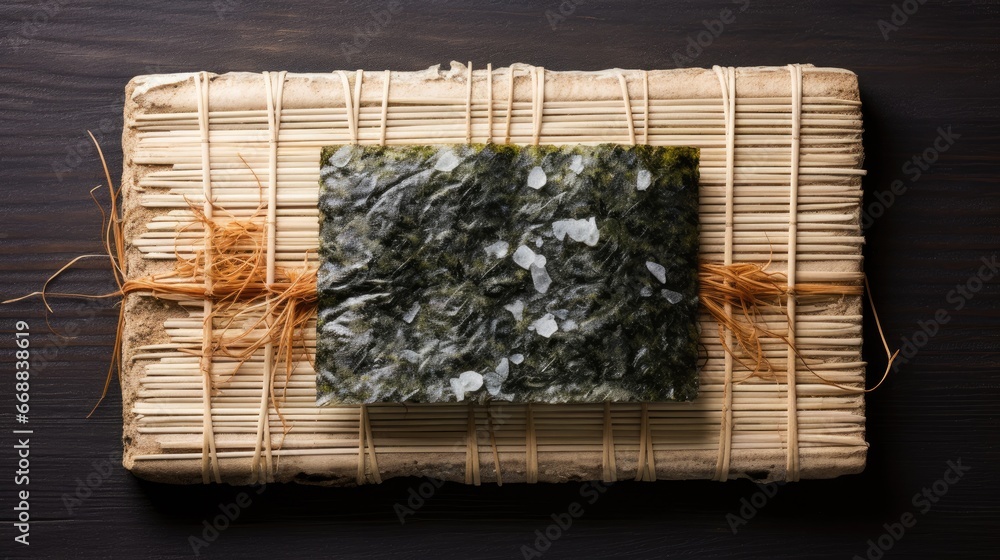 Poster a close up of a piece of paper on a table with a bamboo mat on top of it and a piece of yarn tied to