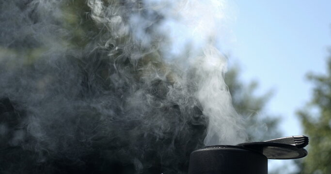 Smoke Billowing from BBQ Hole .Barbecue Prep During Camping Weekend Captured