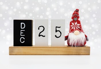 Christmas card with date December 25 and Santa Claus decoration. Snowy background.