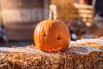 Pumpkin with Carved Face on Straw with Spider Web: Golden Sun Flares and Bokeh