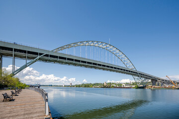 Large arched truss two-story transport Fremont Bridge over the full-flowing Willamette River in Portland Oregon