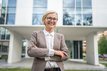 Portrait of one caucasian blonde mature businesswoman stand outdoor