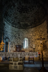 Fototapeta na wymiar Black interior of the Church of Santa Margherita d'Antiochia of altar lighting and religious figures, Vernazza ITALY 