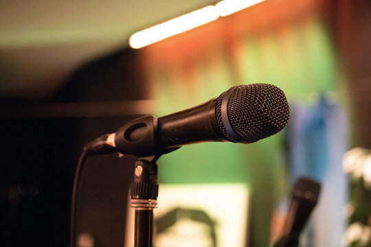 Close up of microphone on stage at church during praise band worship practice with green background