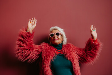 Fashionable elderly woman in stylish eyeglasses looking cool and trendy while dancing 
