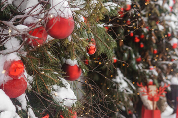 Christmas trees decorated with red balloons in front of the entrance to the cafe. Street Christmas decorations.
